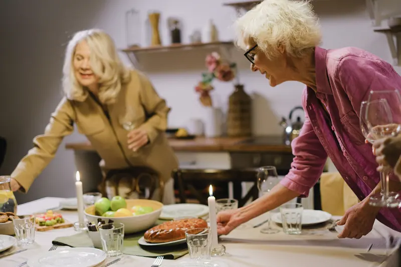 Residents setting the long table for Sunday supper