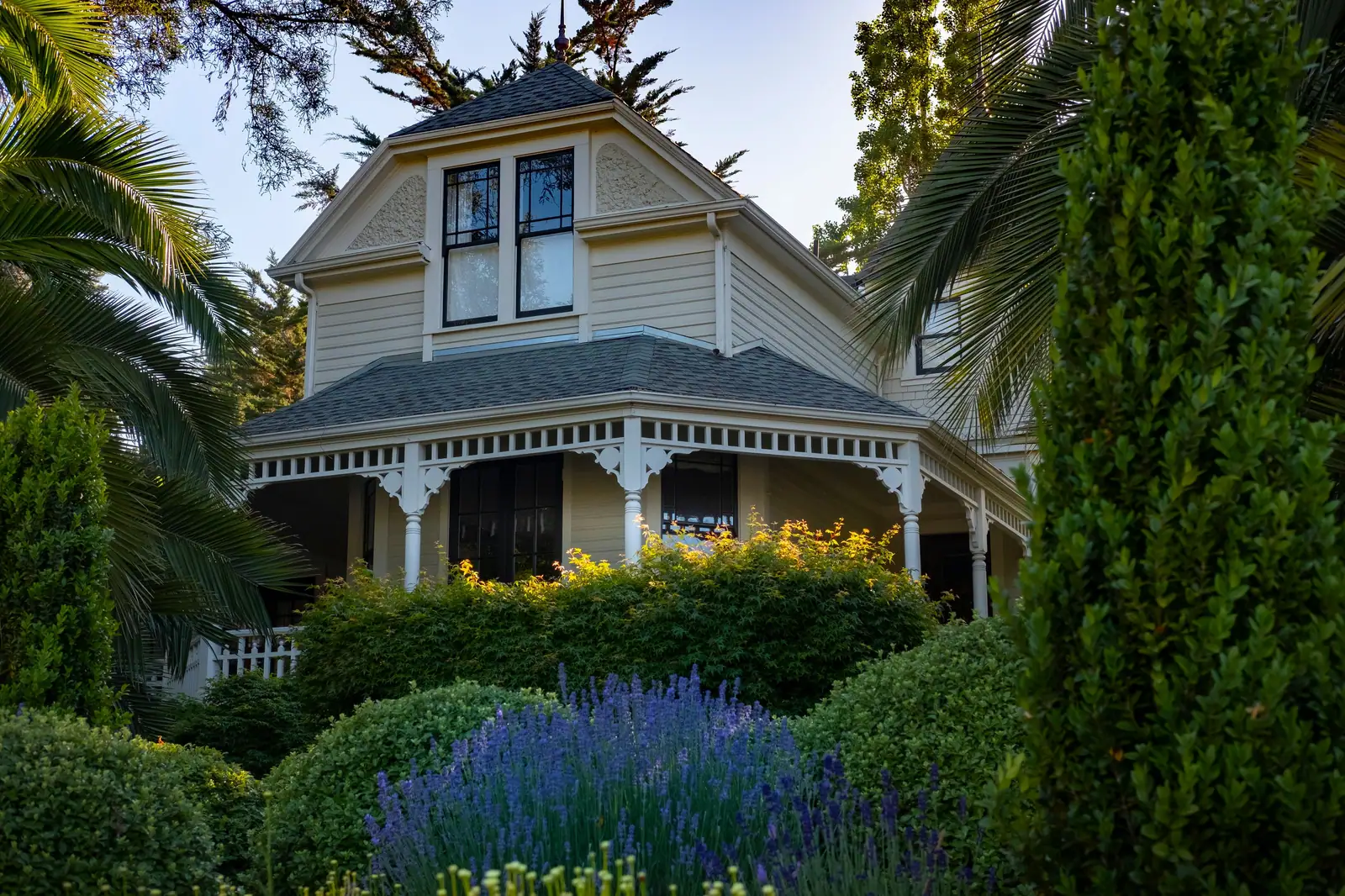 The Hall's original Victorian house, with its wraparound porch and blue salvia along the front walk