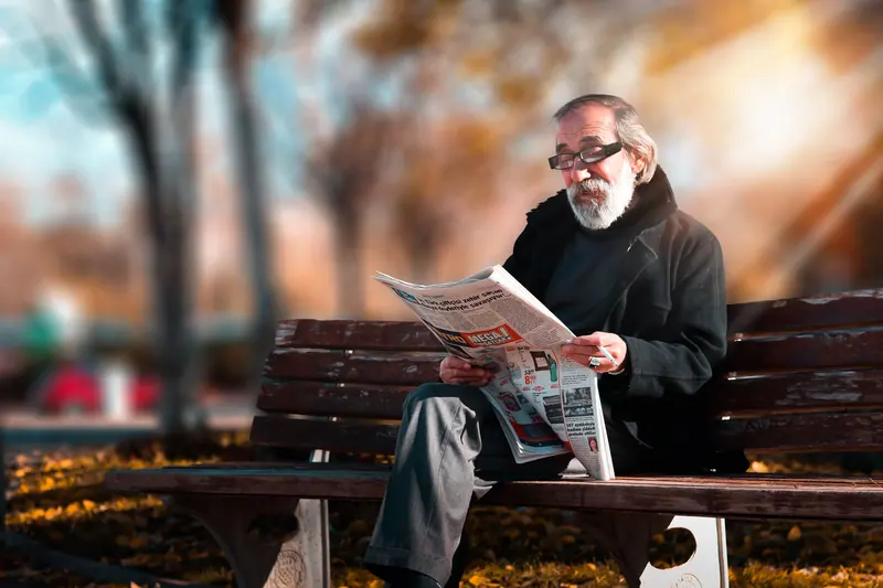 A resident reading the paper on the bench