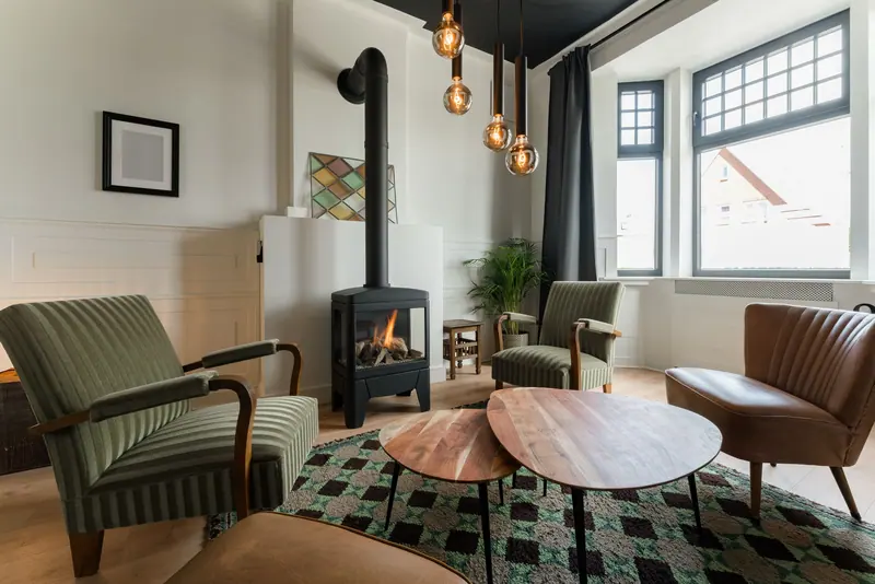 A sitting room with a wood stove and deep chairs
