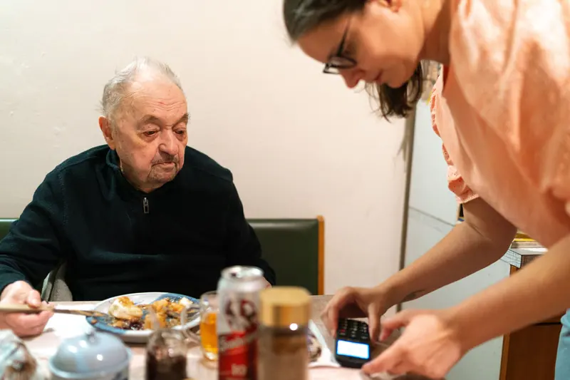 A caregiver helping a resident at lunch