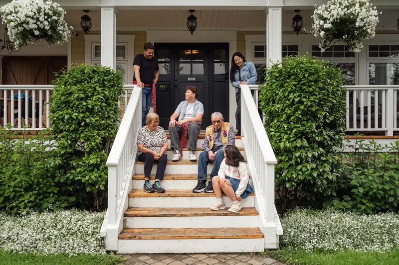 Three generations of a family sitting together on the porch steps