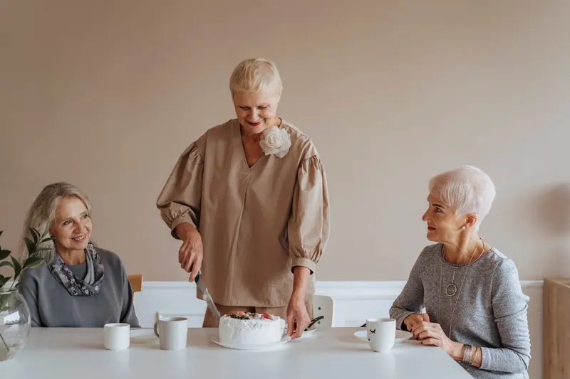 Three residents with a birthday cake