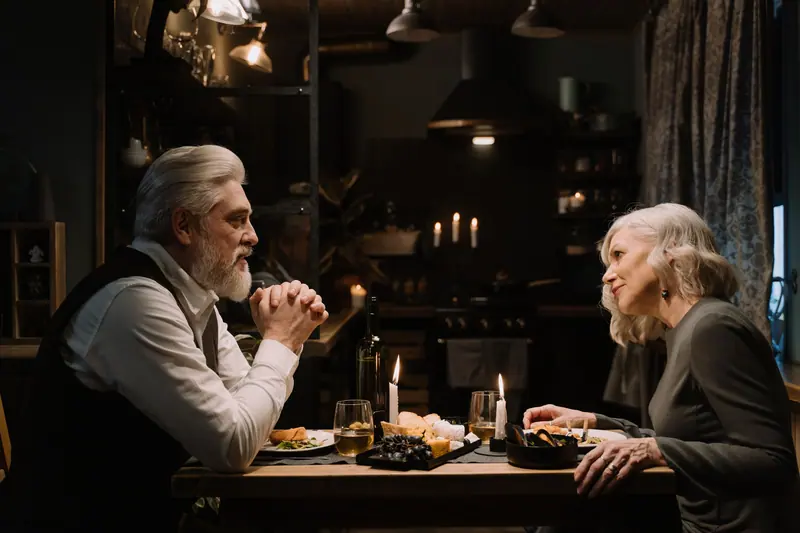 Two residents sharing supper by candlelight at a corner table
