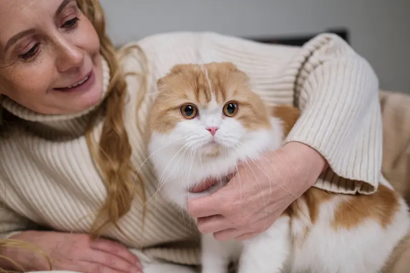A resident cuddling her cat in her apartment