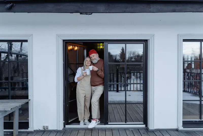 A couple sharing coffee on the porch in winter