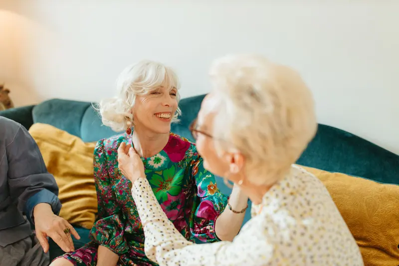 Two residents laughing together on the sofa