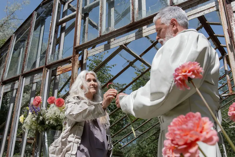 A couple picking flowers in the greenhouse