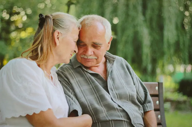 A couple sharing a laugh on a bench by the trail