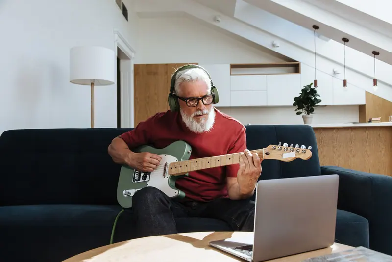 A resident learning a new song on his electric guitar