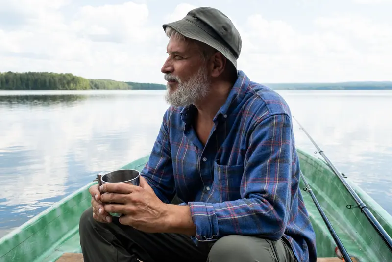 A resident fishing from the bank with his morning coffee