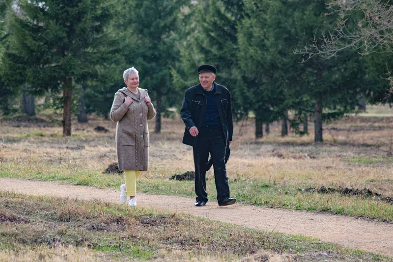Two residents walking the trail through the pines
