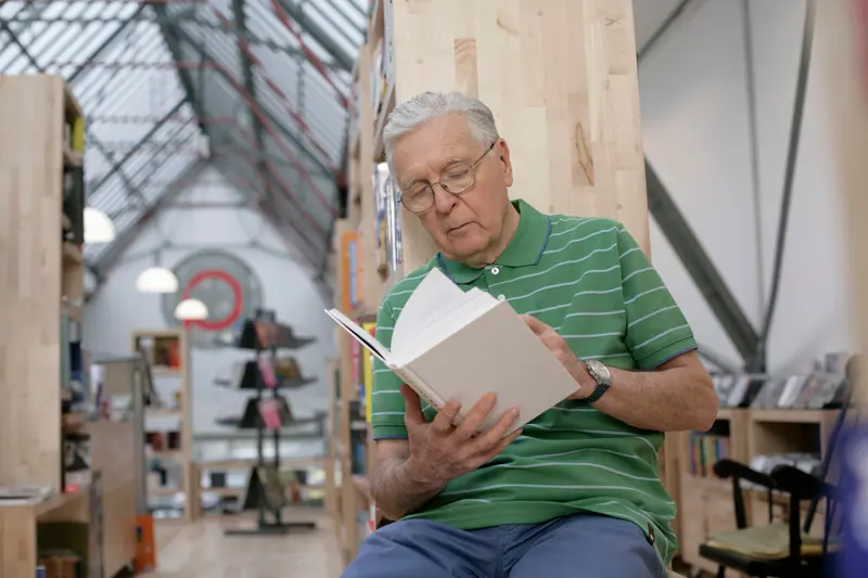 A resident reading in the clubhouse library
