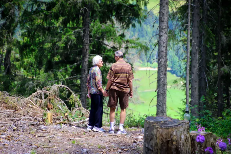 A couple holding hands on the shaded river trail