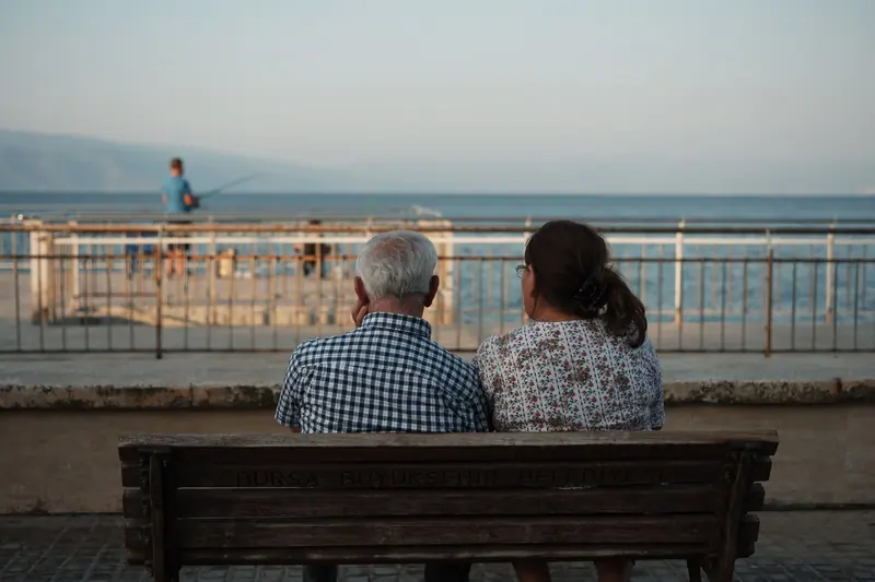 Two residents watching the boats from a bench on the seawall