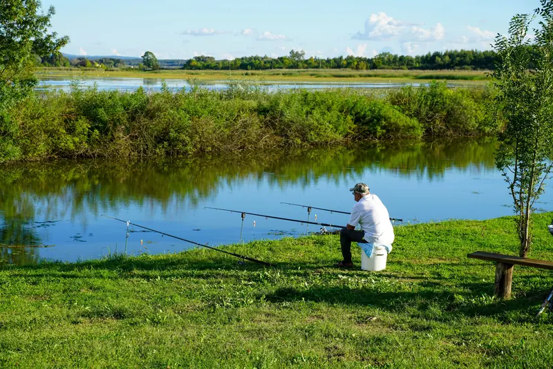 A resident fishing from the grassy bank