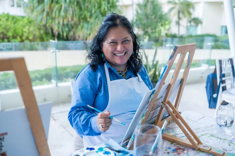 A resident painting at an easel in the art studio
