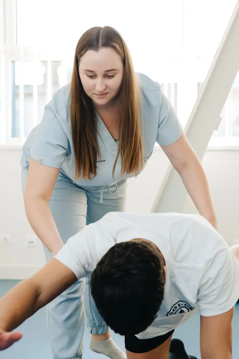 A physical therapist guiding a leg exercise