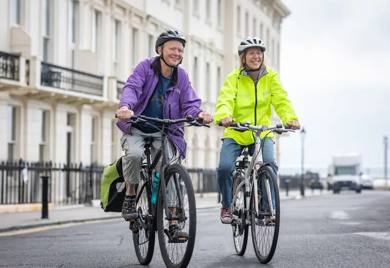 Two residents heading out on their bikes toward the river path