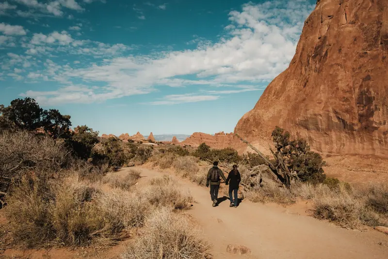 A couple walking a canyon trail on a bright afternoon
