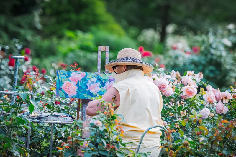 A resident painting roses in the garden during the Thursday class