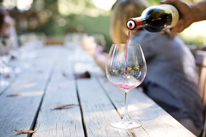 A pour of red at the courtyard table