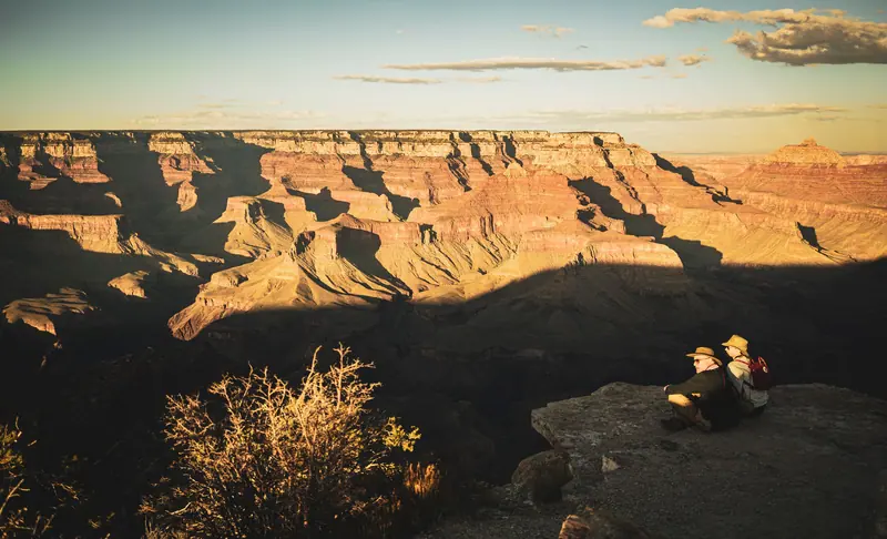Two residents sitting on the rim to watch the sun go down