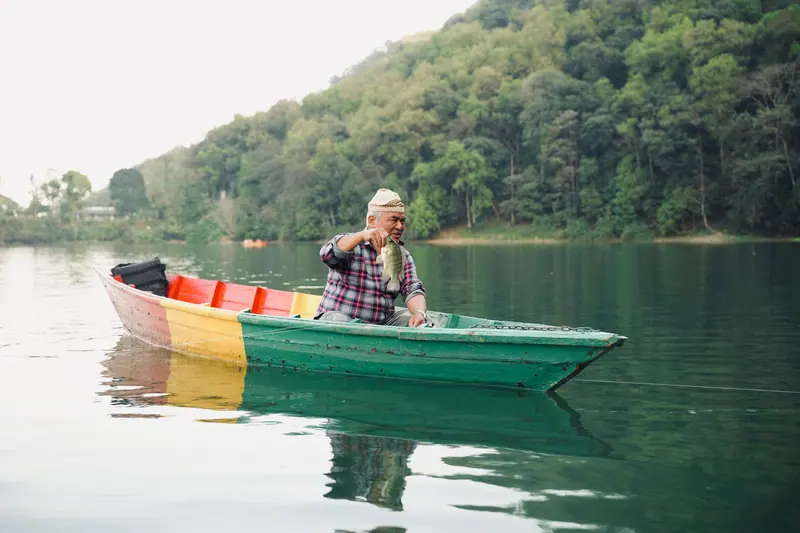 A resident fishing from his rowboat beneath the trees