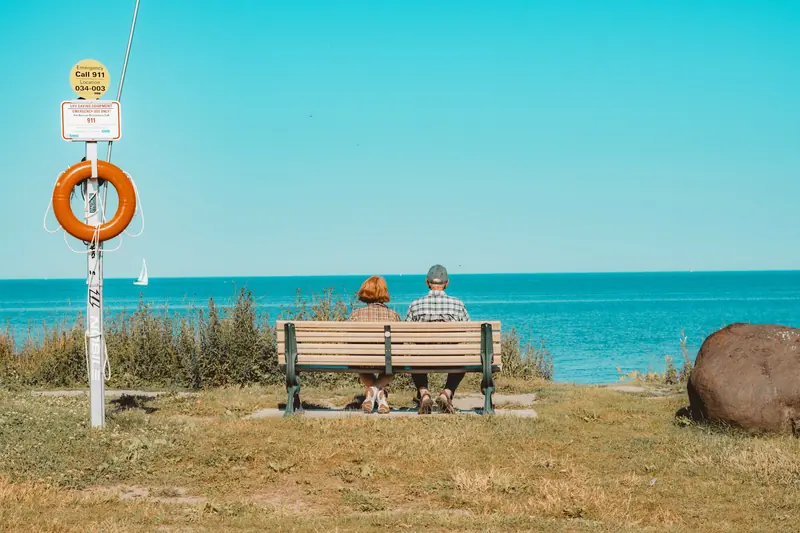 Two neighbors on a bench overlooking the open water