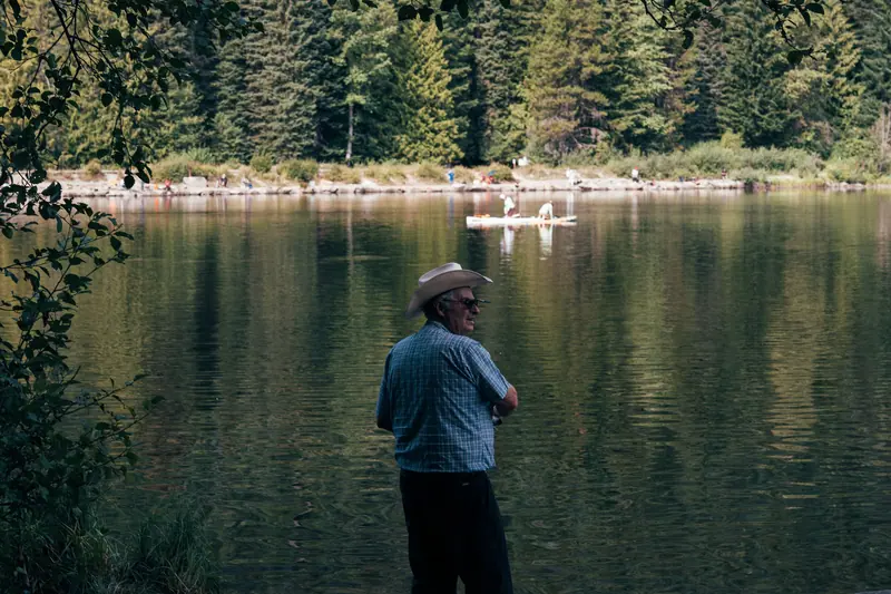 A resident in a cowboy hat looking out over the still water