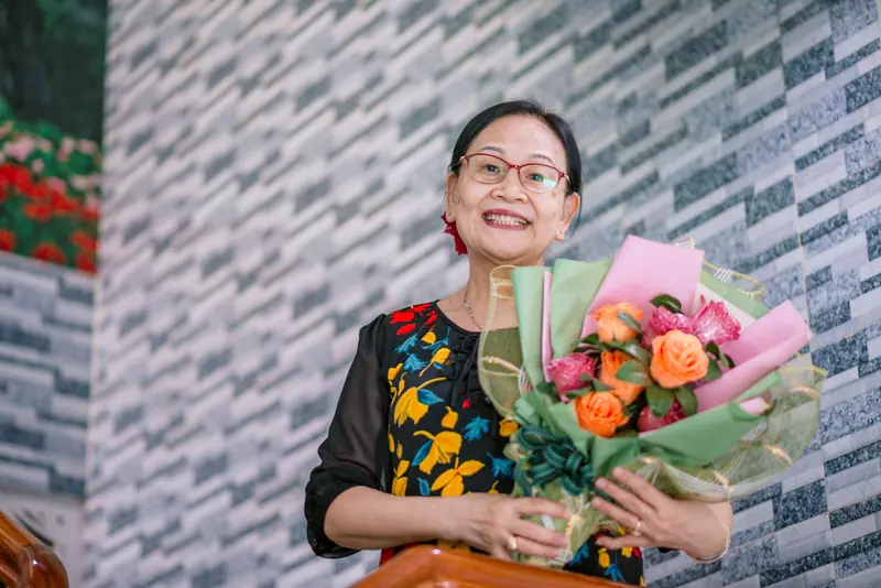 A resident beaming over a bouquet of garden flowers