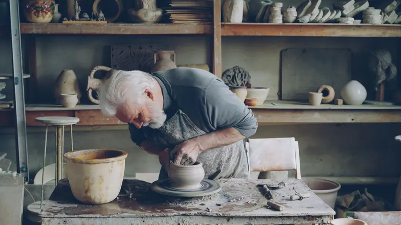 A resident at the pottery wheel in the barn studio