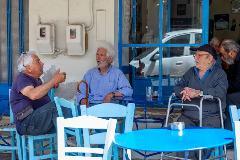 Friends talking over coffee at a sidewalk table