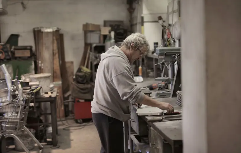 A resident checking a cut at the bandsaw
