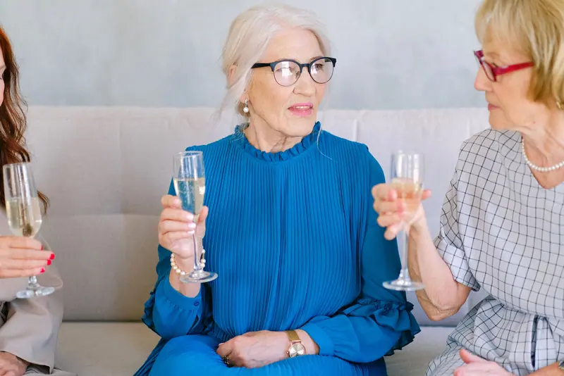 Two friends raising glasses at the anniversary party