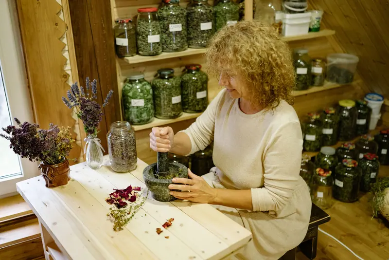 Mixing herbs at the summer-kitchen workbench