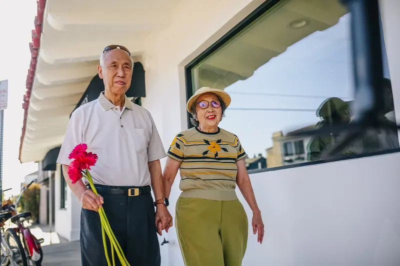 A couple strolling home with fresh flowers from the market