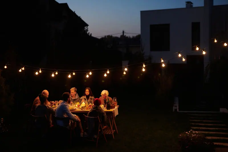 The courtyard supper glowing under string lights