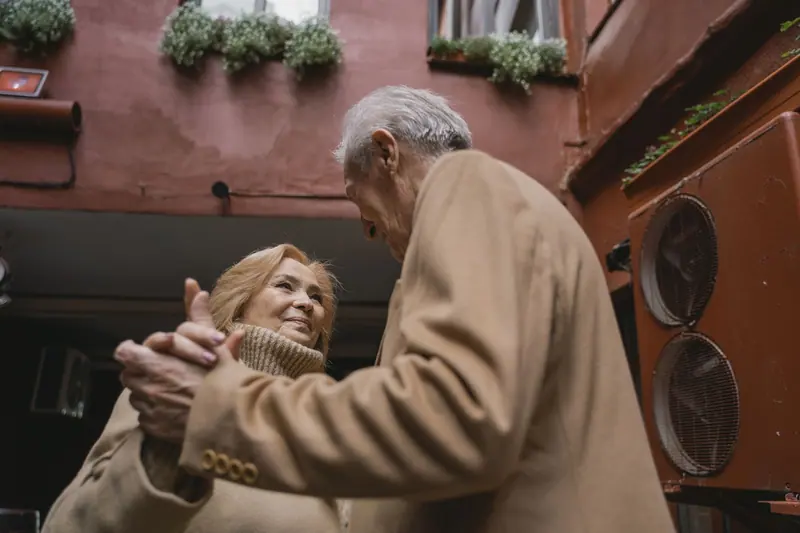 A couple embracing in the courtyard under the window boxes
