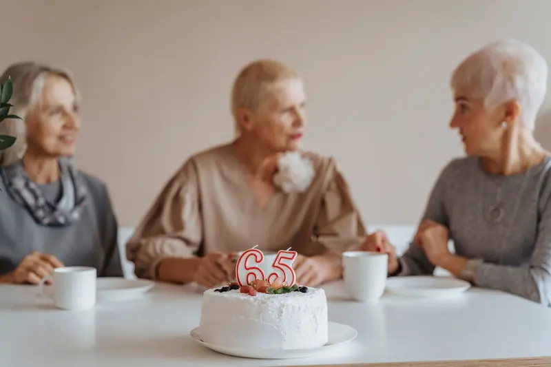 Three residents celebrating a birthday with cake and coffee