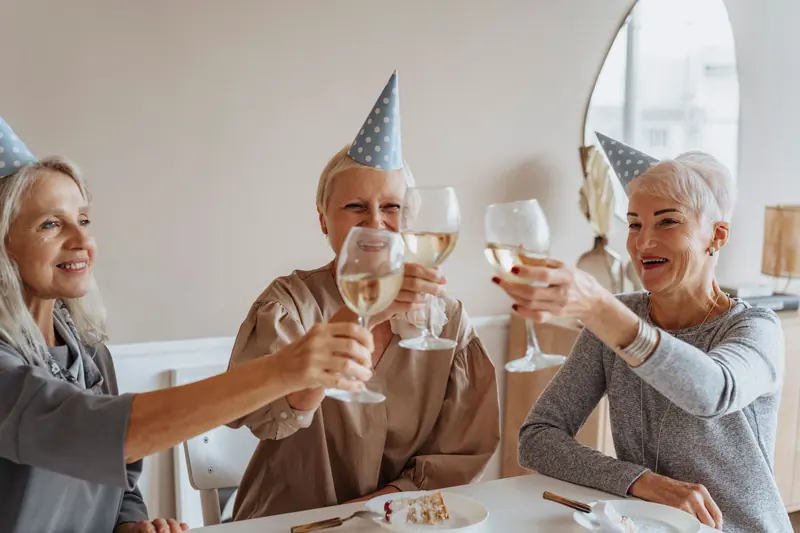 Friends toasting a birthday with party hats on