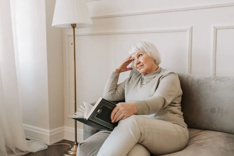 A resident reading on the couch in her apartment