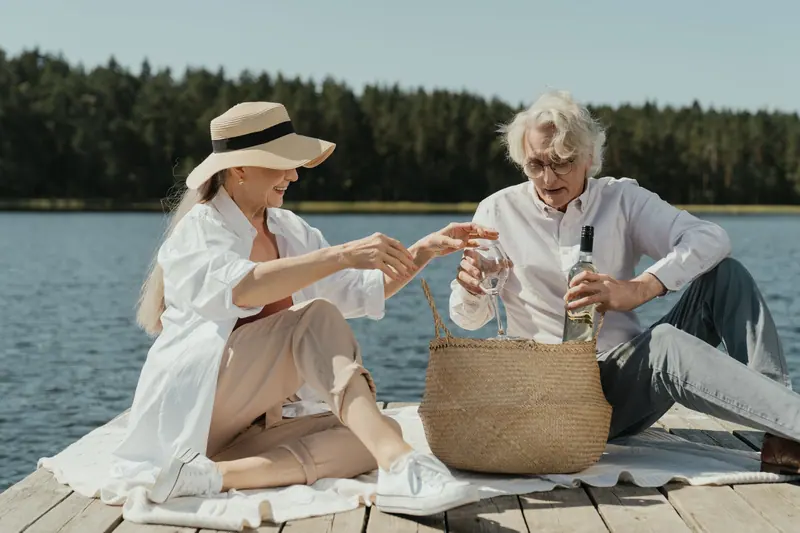 Two friends with a picnic basket by the lake