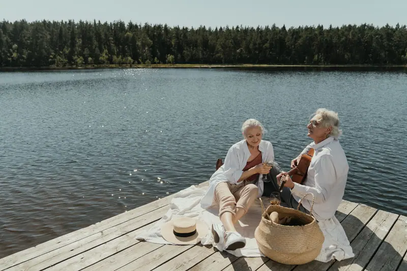A couple relaxing on the dock with a guitar