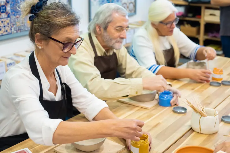 Residents painting pottery at the craft table