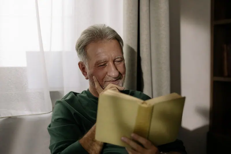 A resident laughing at a passage in his book