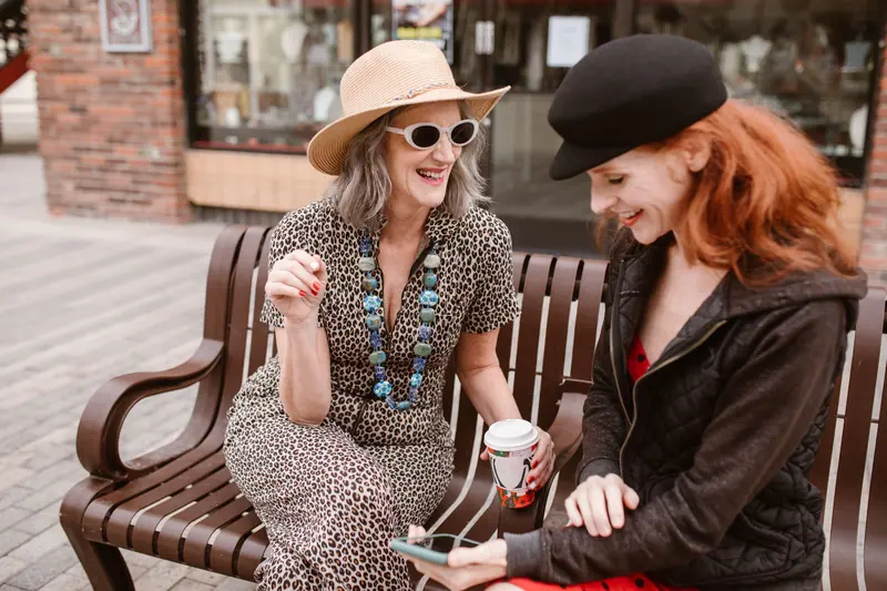 A resident and her granddaughter sharing coffee on a downtown bench