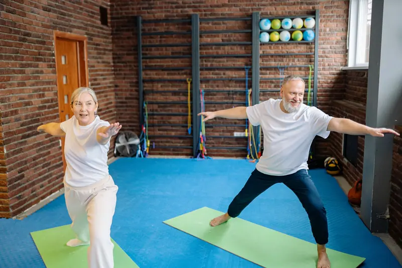 Residents stretching through a morning strength class against the brick wall