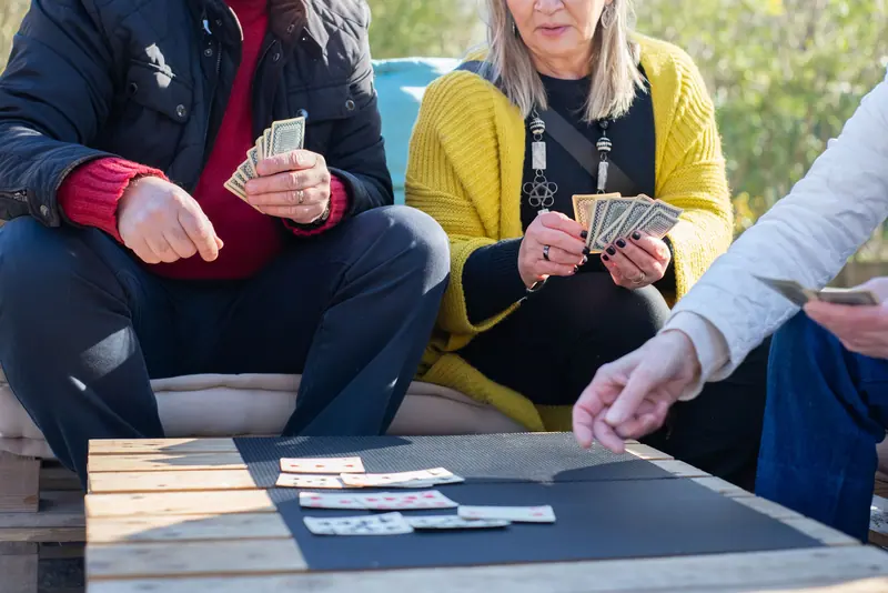 A card game at the picnic tables under the trees