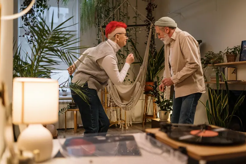 Two residents dancing to a record in their plant-filled loft